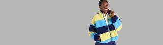 Woman wearing a colorful striped moorlow zip fleece on a gray background
