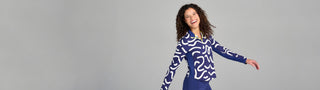 Woman smiling and swinging arms in moorlow Brooksie pullover in The Rally Print with Midnight Mandy bike shorts—comfortable, stylish pickleball activewear for joyful movement.